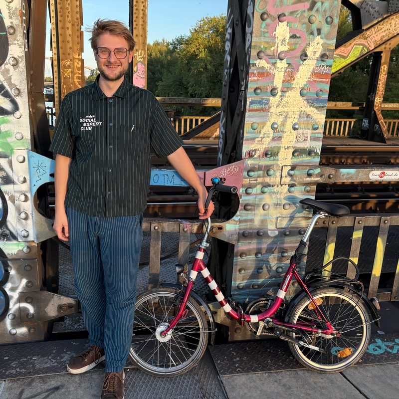 Marko Reinhard with a folding bike on a bridge in Frankfurt am Main, Germany: circular micromobility