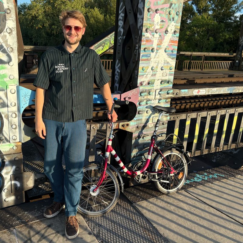 Marko Reinhard with a folding bike on a bridge in Frankfurt am Main, Germany: circular micromobility